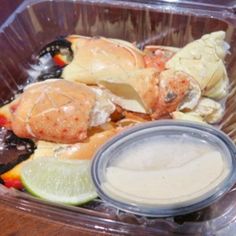 a plastic container filled with food on top of a wooden table