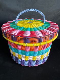 a multicolored basket sitting on top of a black surface