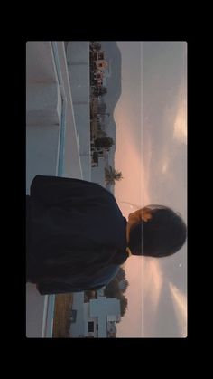 a man standing on top of a roof next to a tall building