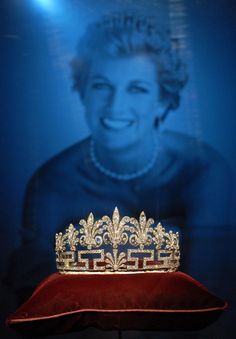 a tiara sitting on top of a red cushion in front of a blue background