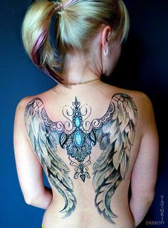 a woman with tattoos on her back and wings