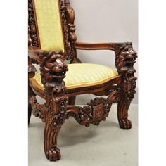 an ornate carved wooden chair with yellow upholstered seat