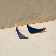 The Story A chic pair of vintage modernist earrings from the mid to late 20th century. Done in warm 14k yellow gold, each earring is made in a sleek triangular shape. Inlayed in each is a richly colored piece of lapis lazuli with natural flecks of gold pyrite scattered throughout. Measuring 0.90 inches tall, the clean lines and simple design give these drop earrings a fantastic look. The Specs Style Number: R3369 Vintage, circa mid to late 20th century 14k yellow gold and lapis lazuli inlay Leng Elegant Triangle Earrings For Formal Occasions, Modern Blue 14k Gold Earrings, Modernist Earrings, Late 20th Century, Lapis Lazuli, Clean Lines, Simple Design, Simple Designs, 20th Century