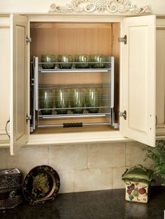 an open cabinet in the kitchen filled with dishes