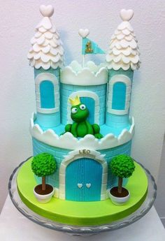 the cake is decorated in blue and green with a frog on it's head