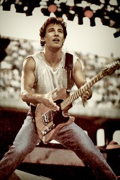 a young man playing an electric guitar on stage