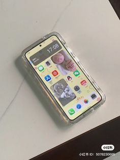 an iphone case sitting on top of a white table next to a cell phone with the image of a baby