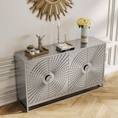 a silver sideboard with an intricate design on the front and sides, against a white wall