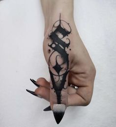 a woman's hand with a black ink tattoo on it