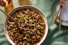 a bowl filled with corn and garnish next to silverware