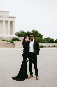 a man and woman standing in front of the lincoln memorial