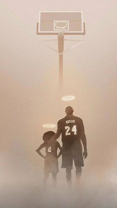 a man and two children standing in front of a basketball hoop with the number 24 on it