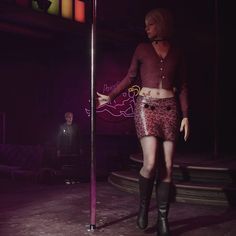 a woman is standing next to a pole in the dark with her hands on her hips