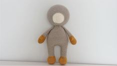 a crocheted stuffed animal is posed against a white wall with its eyes closed