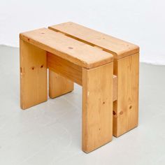 two wooden stools sitting side by side on a white floor with no one around them