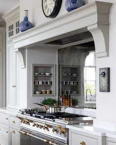 a kitchen with an oven, stove and clock on the wall above it's cabinets