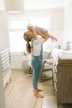 a woman holding a baby up in the air