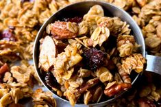 a metal spoon filled with granola on top of a table