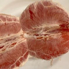 two pieces of meat sitting on top of a white plate