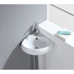 a white sink sitting next to a window with a hose hanging from it's side