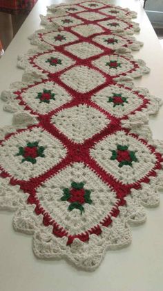 crocheted table runner with red and green stars on the edge, along with white background