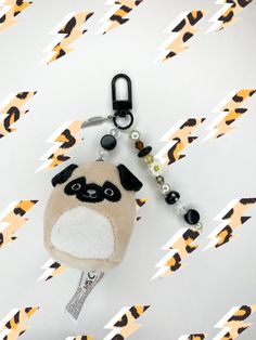 a key chain with a pug on it sitting on top of a white surface