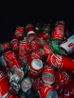 a pile of coca - cola cans sitting next to each other