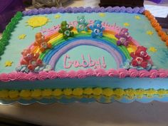 a birthday cake decorated with bears and rainbows