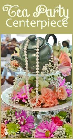 a tea party centerpiece with flowers and pearls on it's tiered tray