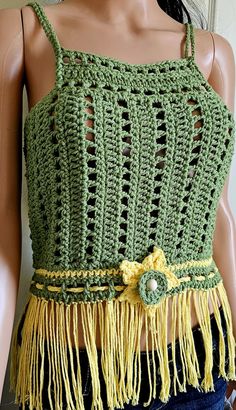 a mannequin wearing a green crochet top with yellow tassels