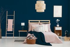 a bedroom with blue walls and pink bedding in the corner, along with baskets on the floor