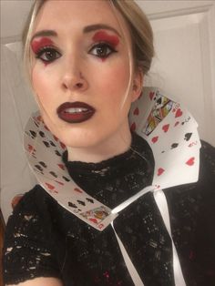 a woman with red lipstick and black eyeliners wearing a white scarf around her neck