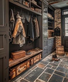 a room filled with lots of wooden furniture and hanging coats on the wall next to an open door