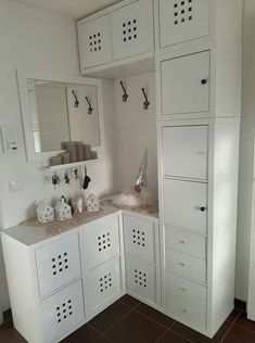 a kitchen with white cabinets and brown tile flooring