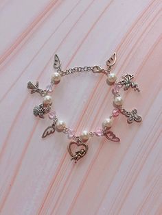 The bracelet is about 6 inches long with an adjustable lobster claw closure. If a different size or extender is needed please feel free to message me (: Bracelet Coquette, Angel Cupid, Pink Y2k, Bracelet Beaded, Cross Charms, Pink Bracelet, Beaded Chain, Angel Wings, Pearl Bracelet