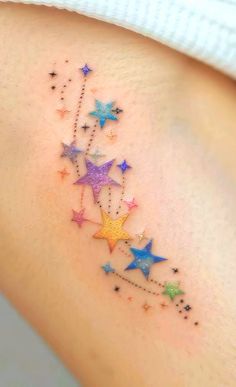 a woman's arm with colorful stars on it