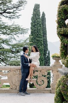 a man and woman standing next to each other on a balcony