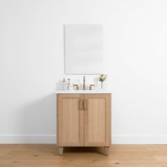 a bathroom vanity with two sinks and a mirror on the wall next to wooden flooring