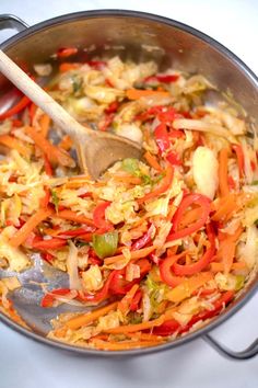 a pan filled with vegetables and a wooden spoon