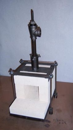 a machine that is sitting on top of a wooden table next to a white box