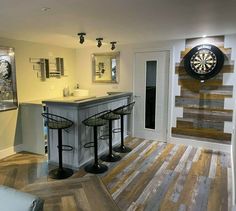 a living room filled with furniture and a dart board wall mounted to the side of it