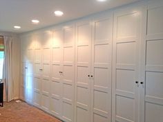 an empty room with white closets and carpeted flooring in front of a window