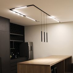 a kitchen with a refrigerator and some lights hanging from the ceiling