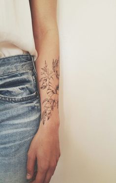 a woman's arm with a flower tattoo on the left side of her arm