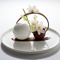 a white plate topped with two vases filled with flowers on top of each other