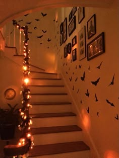 the stairs are decorated with halloween decorations and lite up bats on the wall above them