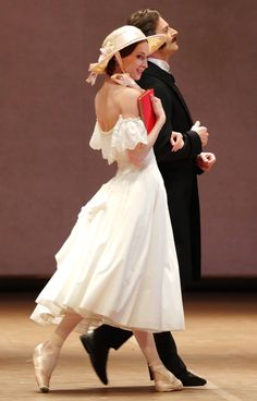 a man and woman in formal dress dancing