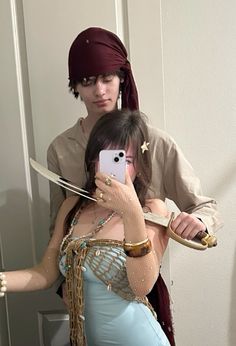 a man and woman dressed in costumes taking a selfie