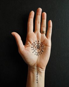 a person's hand with a compass tattoo on it