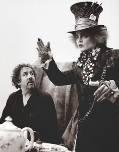 a woman in a top hat sitting next to a man on a couch